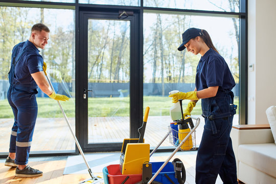 Professional cleaners providing top-rated house cleaning services in Raleigh, NC, using eco-friendly products and modern tools in a residential living room.