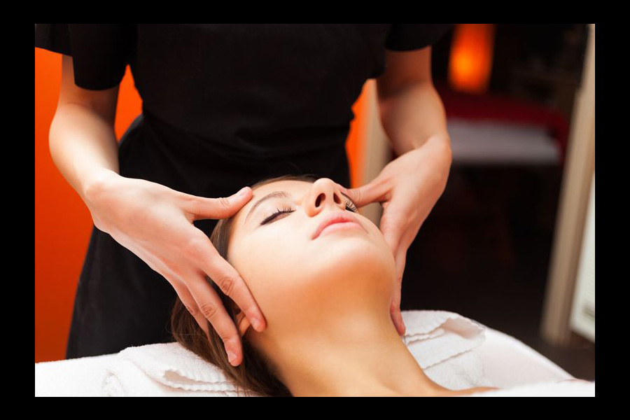 Relaxing Swedish Massage Tysons Corner session focused on head and facial pressure points in a tranquil spa setting.