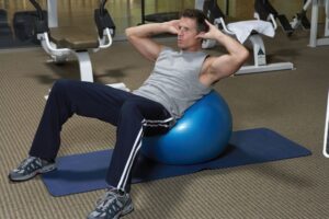 A hardword man perform workout in gym ball.